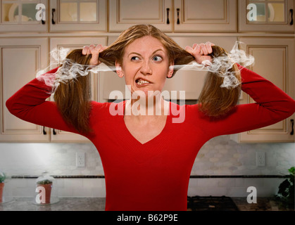 Giovane donna strappando i suoi capelli fuori Foto Stock