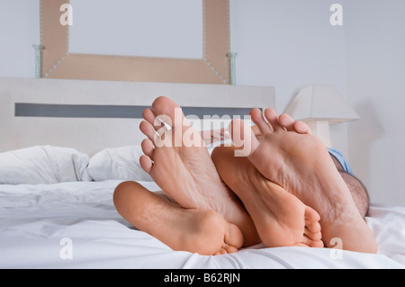 Close-up di piedi di un giovane sul letto Foto Stock