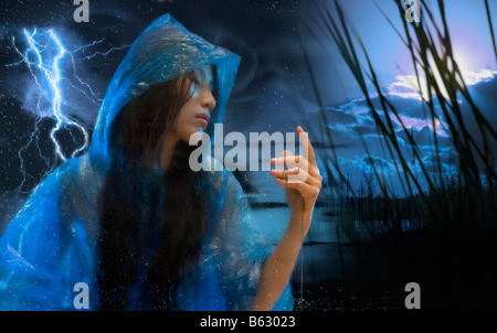 Close-up di una giovane donna in un impermeabile alla ricerca seria Foto Stock