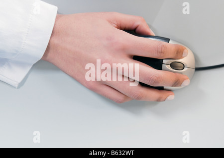 Close-up di una imprenditrice la mano utilizzando un mouse del computer Foto Stock