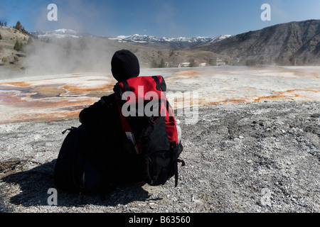 Vista posteriore di una persona seduta di fronte a una primavera calda, Mammoth Hot Springs, Lago Yellowstone, Wyoming USA Foto Stock
