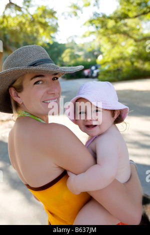 Ritratto di una metà donna adulta che porta la sua bambina e sorridente Foto Stock