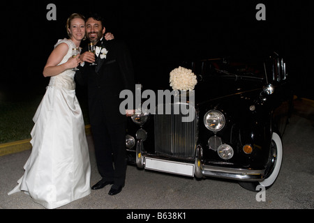 Ritratto di una sposa giovane in piedi e bere champagne Foto Stock