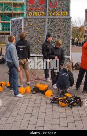 Le persone che stanno imparando l'arrampicata su aperatus per arrampicata utilizzando cavi di sicurezza e caschi nel Regno Unito Foto Stock