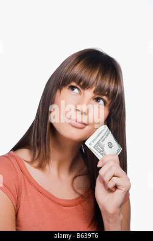 Close-up di una giovane donna che mantiene uno le fatture del dollaro e di pensiero Foto Stock