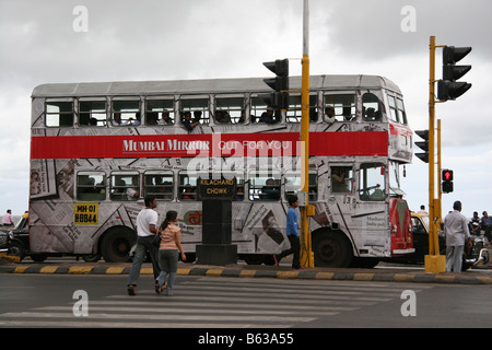 Il semaforo in Mumbai, India. La gente a piedi attraverso la traversata su una luce rossa. Un autobus a due piani è a livello della giunzione. Foto Stock