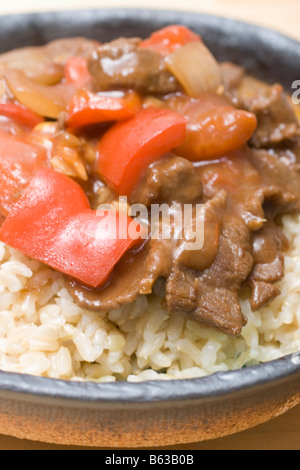 Carni bovine giapponese e pomodoro Stir Fry sul riso marrone Foto Stock