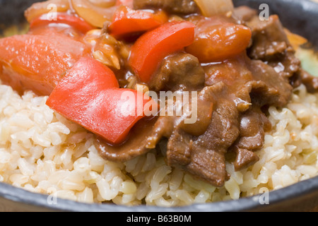 Carni bovine giapponese e pomodoro Stir Fry sul riso marrone Foto Stock