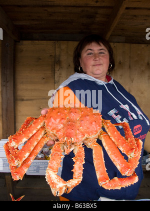 Donna che mantiene un grande granchio rosso di stallo di frutti di mare nel villaggio costiero sull isola di Sakhalin in Russia 2008 Foto Stock