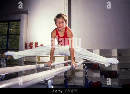 Ragazzo esegue la ginnastica su barre parallele. Foto Stock