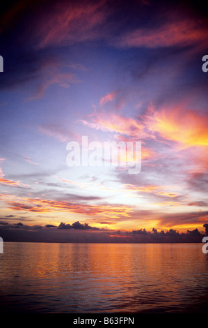 Tramonto maldiviano su una calma Oceano Indiano, nelle Maldive. Gli atolli del nord. Foto Stock