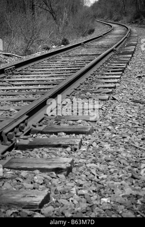 I binari della ferrovia della curvatura fuori nella distanza avanti Foto Stock