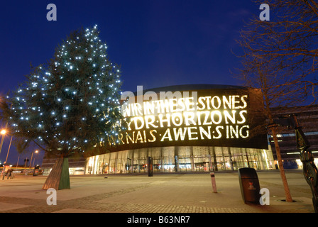 Il Wales Millennium Centre di Cardiff illuminata di sera con un albero di Natale al di fuori Foto Stock