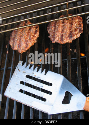 Due hamburger cucinare alla griglia Foto Stock