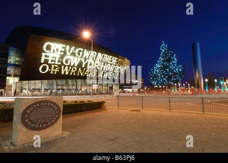 Il Wales Millennium Centre di Cardiff illuminata di sera con un albero di Natale al di fuori Foto Stock