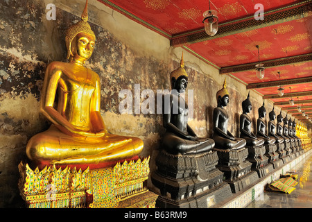 Le immagini del Buddha in posizione di meditazione al Wat Suthat tempio buddista complesso di Bangkok, Thailandia Foto Stock
