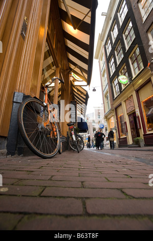 Biciclette magra contro una parete in una strada stretta IN AMSTERDAM Foto Stock