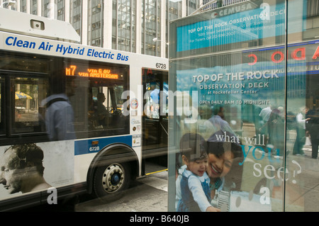 Aria pulita ibrido Bus elettrico, pubblicità e riflessioni presso la fermata degli autobus a Manhattan, New York, Stati Uniti d'America. Foto Stock