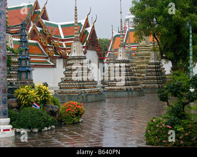 Gli stupa sotto la pioggia al Wat Pho tempio a Bangkok in Tailandia Foto Stock