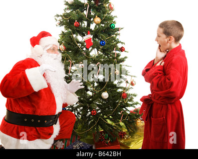 Little Boy catture Santa nell'atto di portare i regali di Natale sfondo bianco Foto Stock