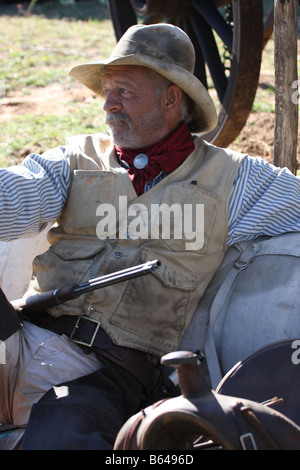 Un vecchio cowboy timer appoggiata contro il suo pack e la sella accanto alla Chuck wagon Foto Stock