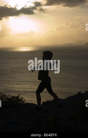 Silhouette di boy gettando una roccia San Giovanni USVI Foto Stock