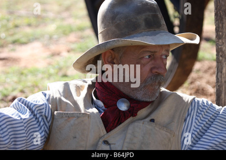 Un vecchio cowboy timer appoggiata contro il suo pack e la sella accanto alla Chuck wagon Foto Stock