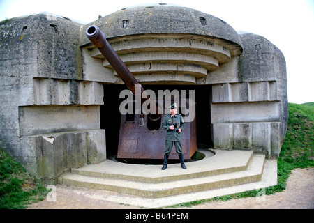 Un attore vestito come un ufficiale tedesco che si affaccia sul canale in lingua inglese e da un tedesco D Day Gun batteria in Normandia Francia Foto Stock