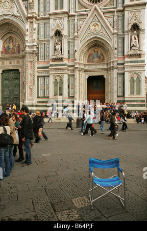 Vuota la sedia pieghevole e turisti al di fuori del Duomo o Santa Maria del Fiore di Firenze (Italia). Foto Stock