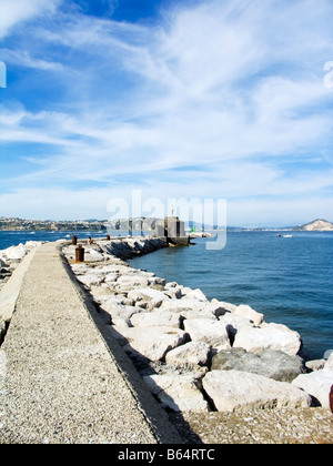 Scogliera artificiale e percorso del faro nel porto di Isola di Procida Napoli Campania Italia Foto Stock