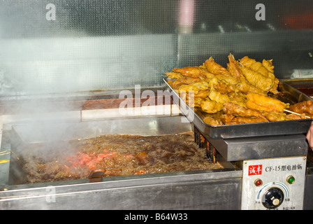 Stallo alimentare shop la preparazione di fritti di carne e di pesce per la vendita in ex City God Temple area dello shopping vicino a Old Street di Shanghai Foto Stock