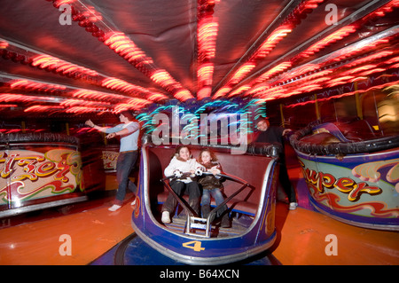 Due giovani pre-teen 10 enne ragazze amici avente scary divertimento sul waltzer guidare in una fiera di notte REGNO UNITO Foto Stock