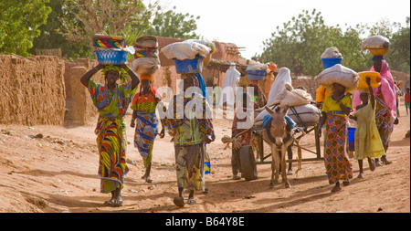 Un gruppo di donne di casa di testa ai loro villaggi dopo una lunga giornata al settimanale del venerdì nel mercato Torodi, Niger. Foto Stock