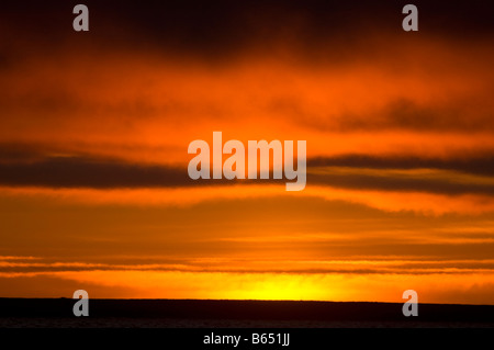 Il tramonto estivo si riflette in modo lucente nelle nuvole su un mare privo di ghiaccio nell'area Beaufort Sea 1002 dell'Arctic National Wildlife Refuge, North Slope, Alaska Foto Stock