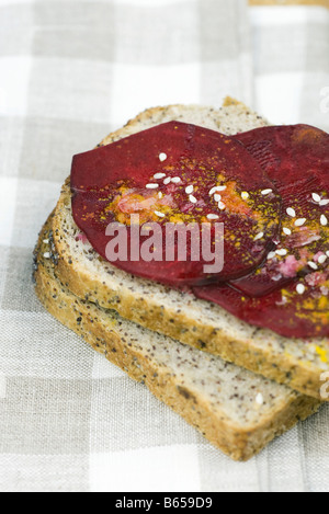 Fette di barbabietole sul pane condito con semi di sesamo e spezie Foto Stock