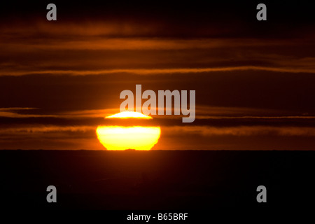 Estate glowingly tramonto riflesso in nuvole sopra un mare di ghiaccio libera Beaufort Sea Foto Stock