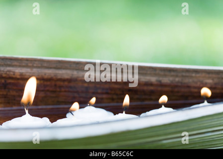 Acceso candele votive in ambiente naturale Foto Stock