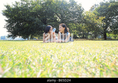 Due giovani donne sdraiati sull'erba Foto Stock