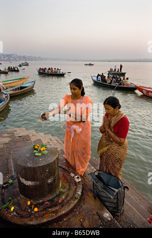 India, Uttar Pradesh, Varanasi, Ganga river, donne eseguendo puja, un rituale per le offerte Foto Stock