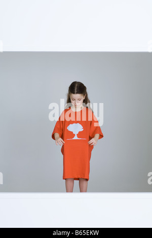 Bambina indossa tee-shirt con cloud a fungo stampati su di essa Foto Stock