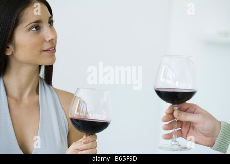 Giovane Azienda di bicchieri di vino rosso, vista ritagliata Foto Stock