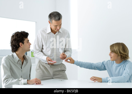 Coppia padre e i due figli giocare a carte Foto Stock