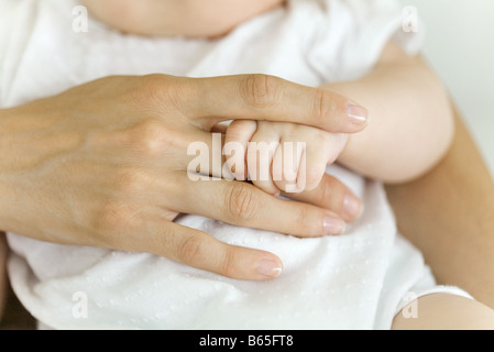 Baby la mano azienda adulto del dito, close-up Foto Stock