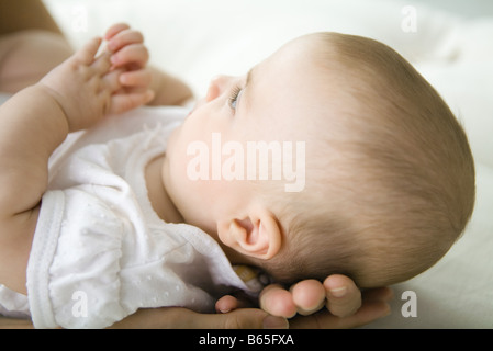 Bambino giacente su madre le mani, ritagliato Foto Stock