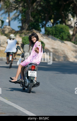 Donna Thai riding pillion in tipico stile tailandese su un motociclo di luce Foto Stock