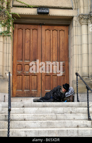 Anziani senzatetto uomo dorme in una porta nel centro cittadino di Montreal, Quebec, Canada Foto Stock