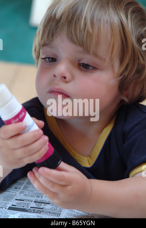 Little Boy tenendo un bastoncino di colla Foto Stock