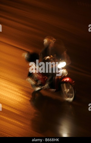 Fast moto rider heavy rain di notte in città Foto Stock