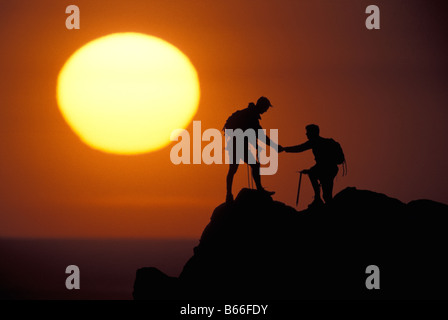 Due scalatori raggiungono il vertice di sunrise. Foto Stock