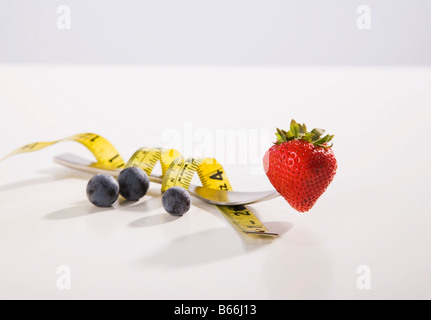 Metro a nastro avvolto intorno a forcella con fragola Foto Stock